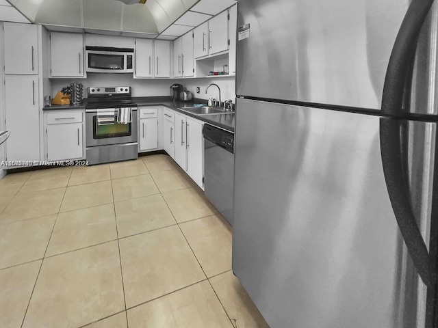 kitchen featuring white cabinets, sink, light tile patterned floors, and appliances with stainless steel finishes