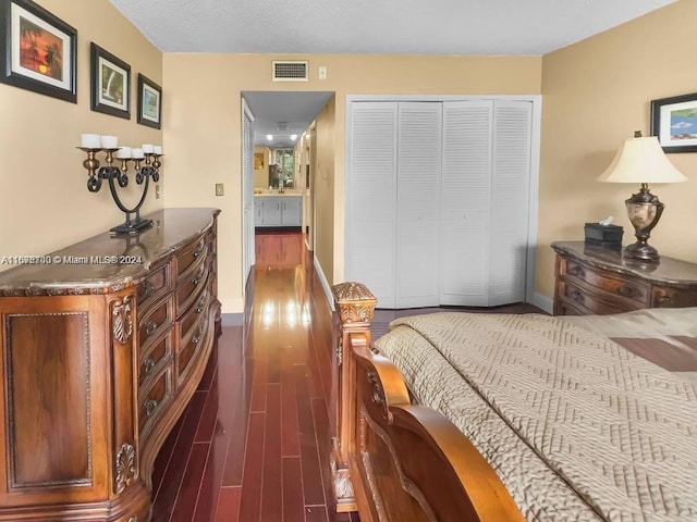 bedroom with dark hardwood / wood-style flooring and a closet