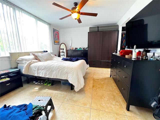 bedroom featuring light tile patterned floors, multiple windows, and ceiling fan