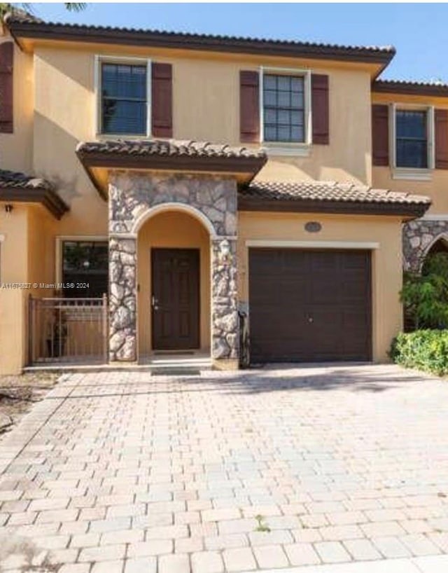 mediterranean / spanish home featuring a garage