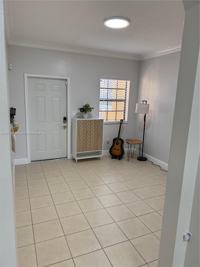 foyer with ornamental molding and light tile patterned floors