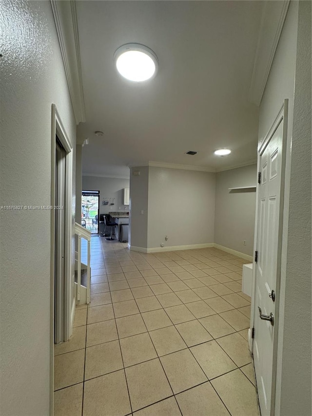 spare room with crown molding and light tile patterned floors