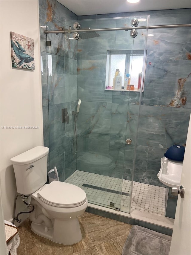 bathroom featuring walk in shower and toilet