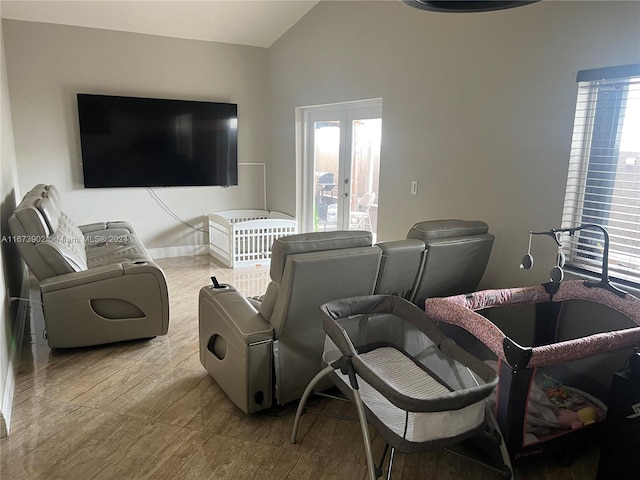 living room featuring vaulted ceiling, light hardwood / wood-style floors, and french doors