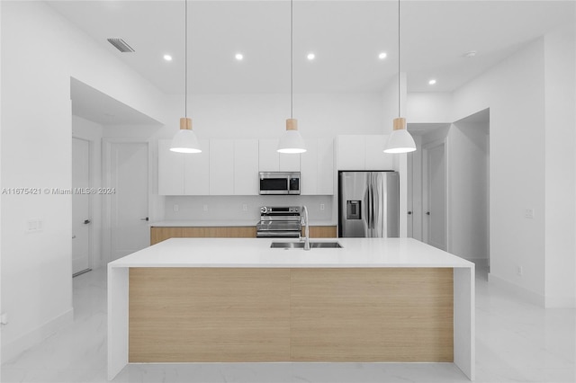 kitchen with sink, a spacious island, white cabinetry, stainless steel appliances, and decorative light fixtures