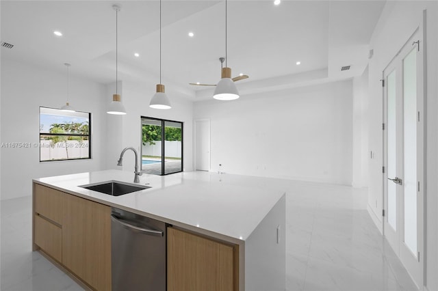 kitchen with hanging light fixtures, a raised ceiling, a large island with sink, dishwasher, and sink