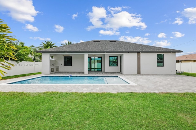 back of property featuring a fenced in pool, a lawn, and a patio area