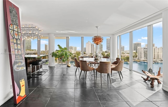 sunroom / solarium with a notable chandelier and a water view