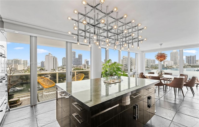 sunroom / solarium featuring a water view, a notable chandelier, and plenty of natural light