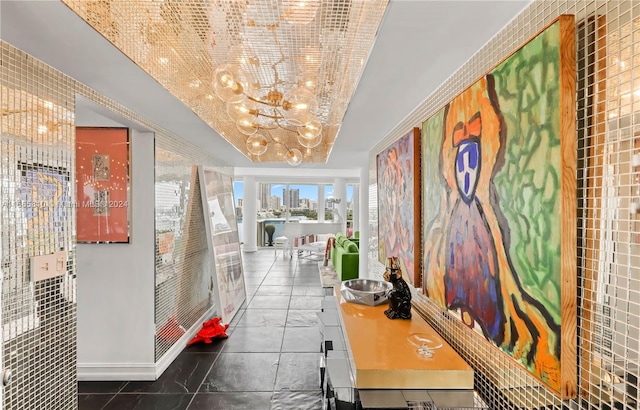 hall with a chandelier and tile patterned floors