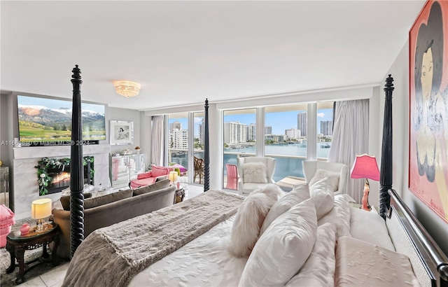 bedroom with access to outside, a wall of windows, and a water view