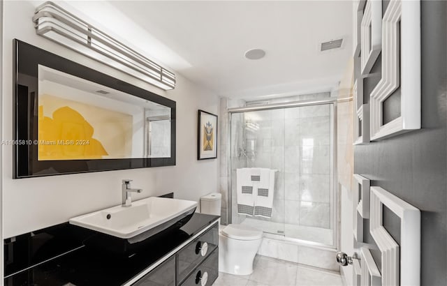 bathroom featuring vanity, toilet, a shower with door, and tile patterned floors