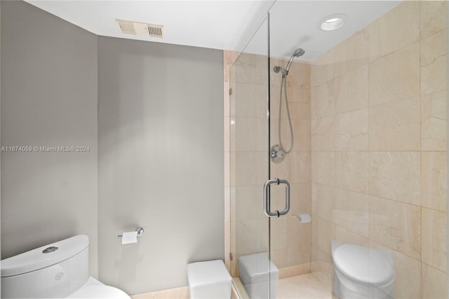 bathroom with toilet and a shower with shower door