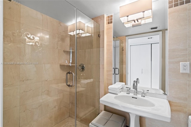 bathroom featuring sink, walk in shower, and tile walls