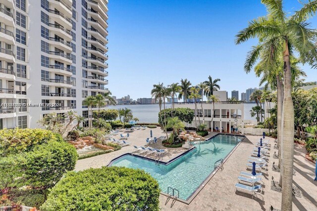 view of swimming pool featuring a patio area and a water view