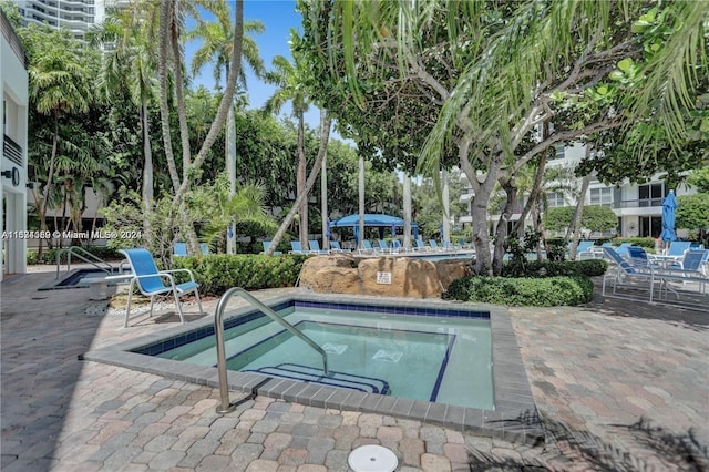 view of swimming pool with a patio area and a hot tub