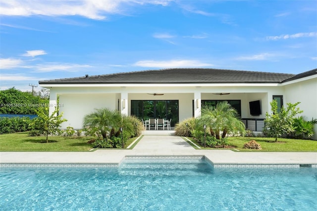 view of swimming pool with ceiling fan and a lawn