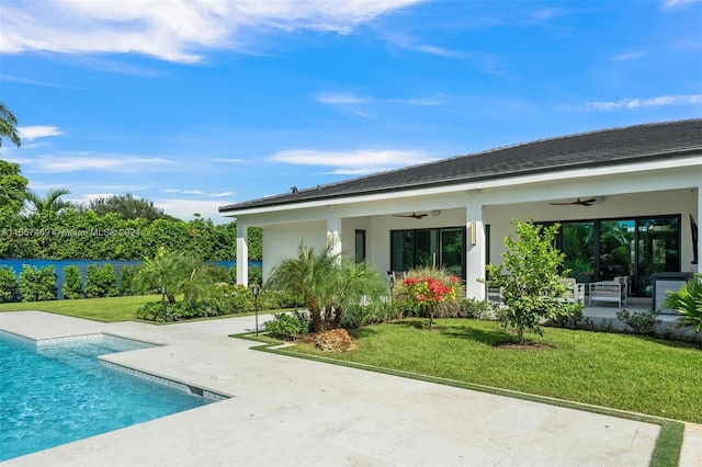 back of house with ceiling fan, a lawn, and a patio area