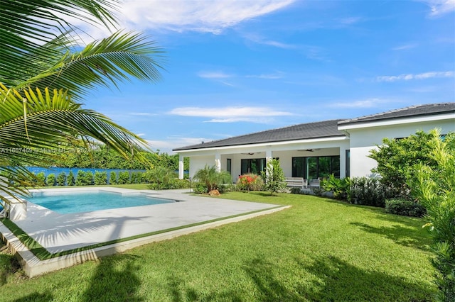 view of pool featuring ceiling fan, a yard, and a patio