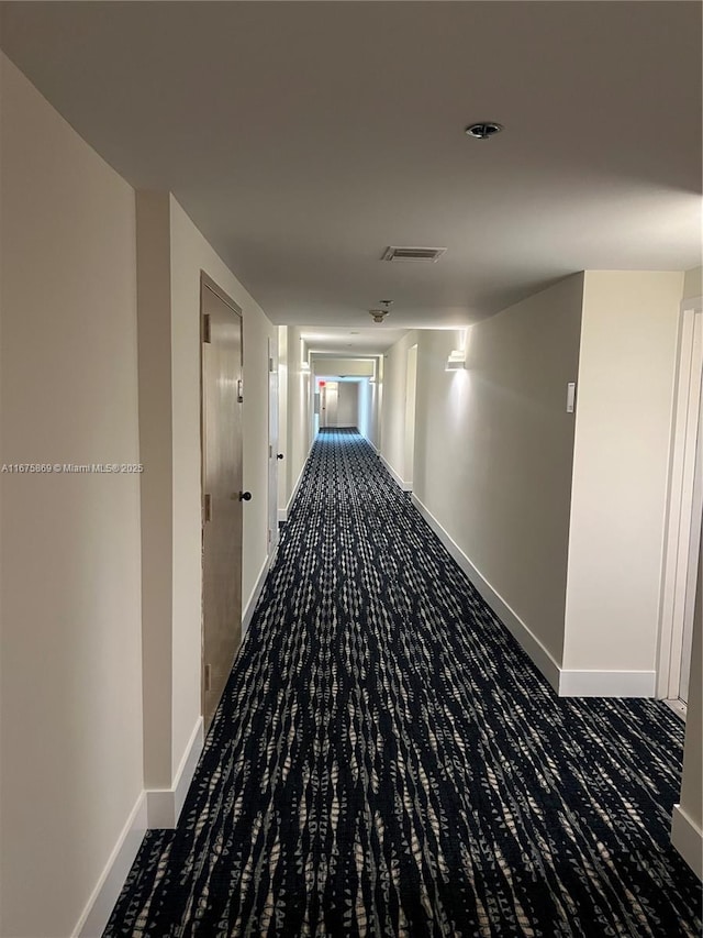 hallway with dark colored carpet