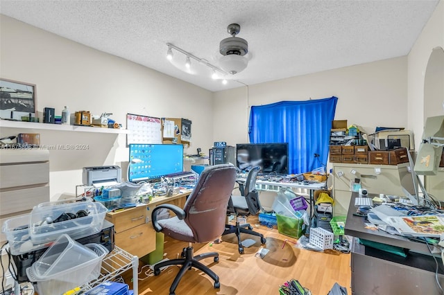 office space with track lighting, wood-type flooring, and a textured ceiling