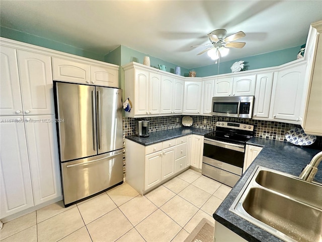 kitchen featuring tasteful backsplash, light tile patterned floors, white cabinetry, sink, and stainless steel appliances