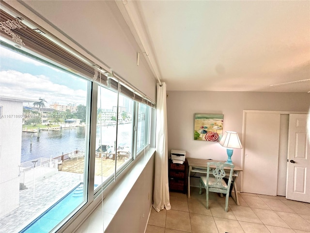 dining room featuring a water view, plenty of natural light, and light tile patterned floors