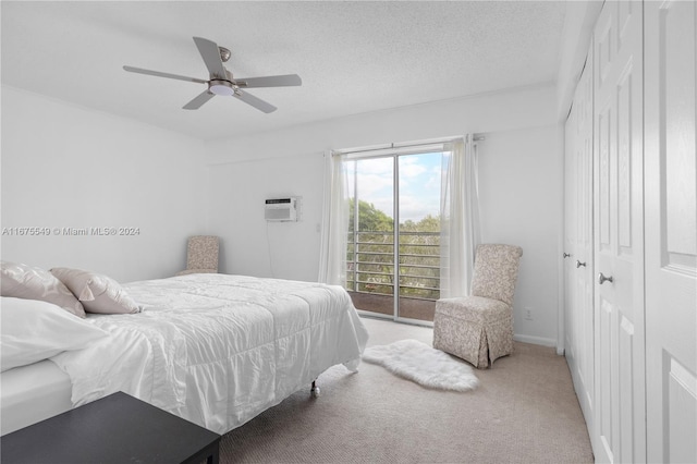 bedroom featuring a wall mounted air conditioner, ceiling fan, a textured ceiling, a closet, and carpet floors