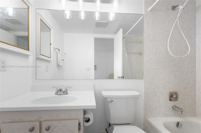 full bathroom with vanity, tiled shower / bath combo, and toilet