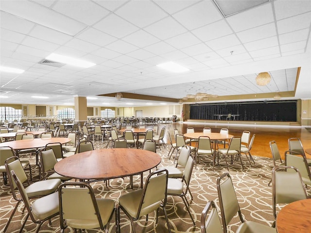 carpeted dining room with a drop ceiling