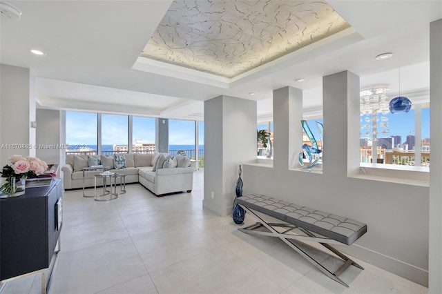 living room with a tray ceiling and a healthy amount of sunlight