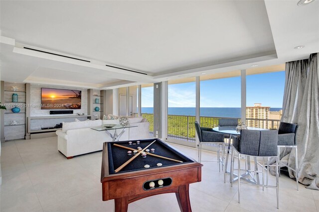 game room with a water view, light tile patterned floors, and billiards