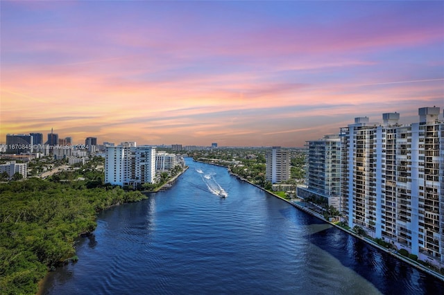 aerial view at dusk featuring a water view