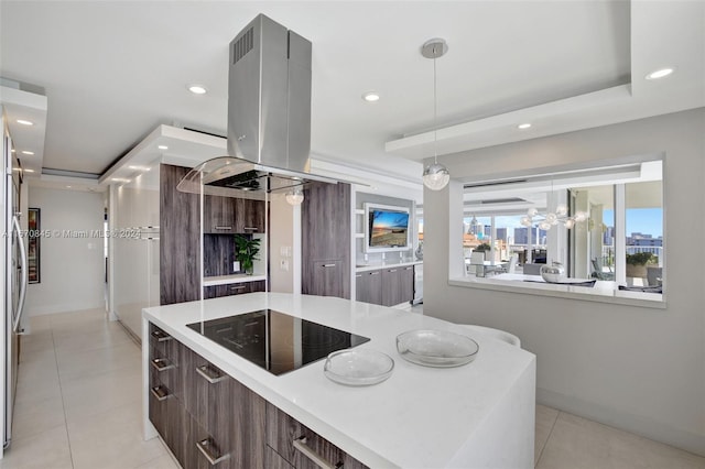 kitchen featuring light tile patterned floors, a kitchen island, island range hood, decorative light fixtures, and black electric stovetop