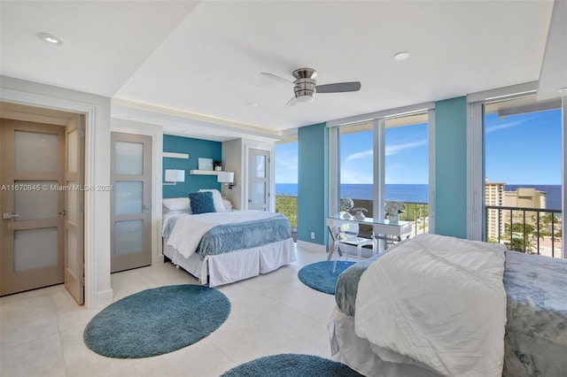 bedroom with ceiling fan, access to exterior, and a water view