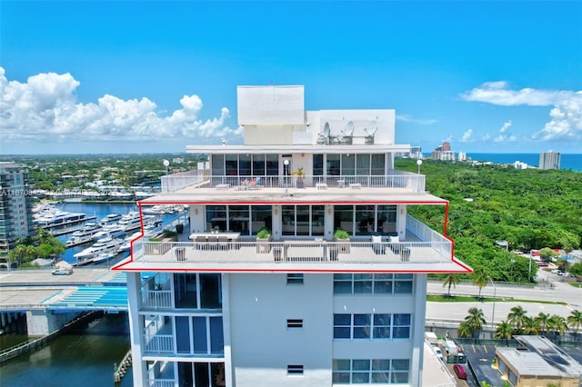 back of house with a water view and a balcony