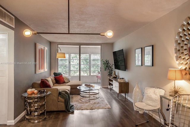 living area featuring dark wood-style floors, visible vents, and baseboards