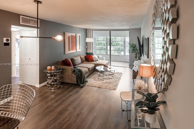 living room with dark hardwood / wood-style floors and a textured ceiling