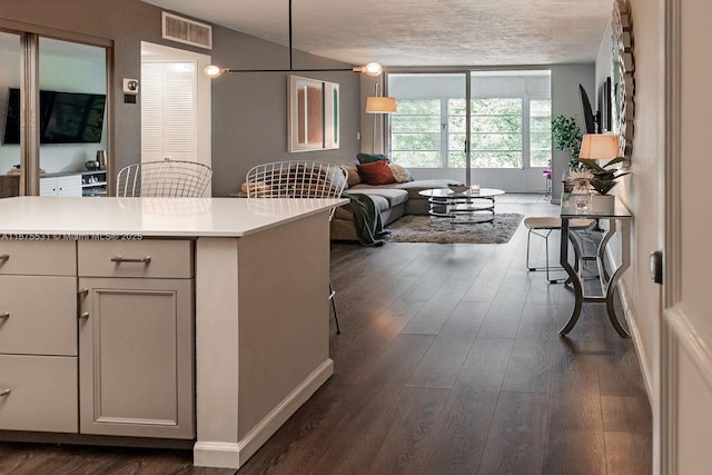 kitchen with open floor plan, light countertops, hanging light fixtures, and white cabinets