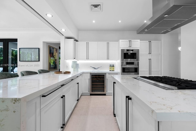 kitchen featuring extractor fan, wine cooler, a kitchen bar, stainless steel appliances, and light stone countertops