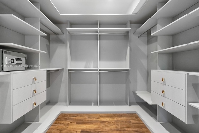 walk in closet with hardwood / wood-style floors