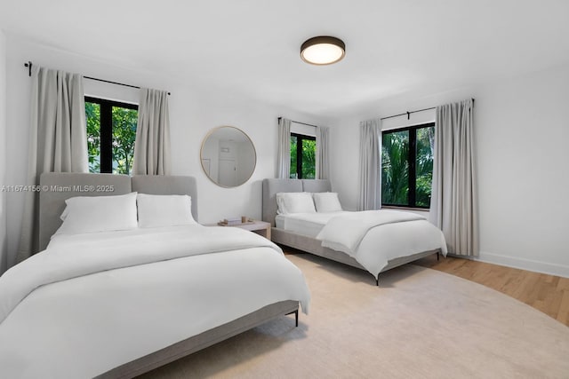 bedroom with hardwood / wood-style floors and multiple windows