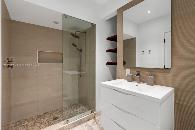 bathroom with vanity and a tile shower