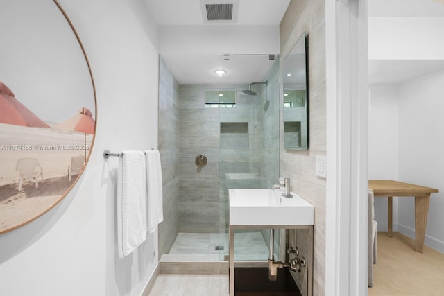 bathroom featuring vanity and tiled shower