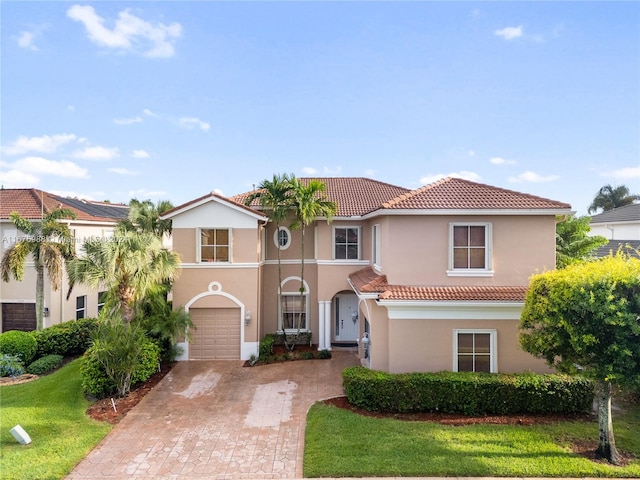 mediterranean / spanish-style house featuring a front yard and a garage