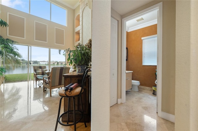 corridor featuring crown molding and a water view