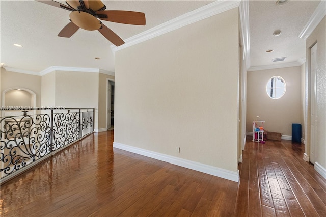 spare room with dark wood-type flooring, ornamental molding, and a textured ceiling