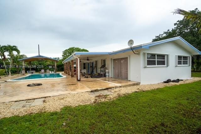 rear view of house with a gazebo, ceiling fan, a yard, and a patio