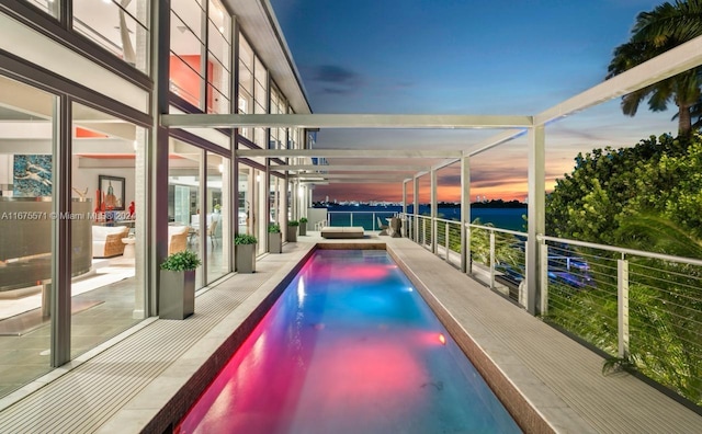 pool at dusk featuring a patio area