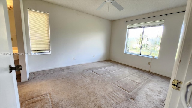 carpeted spare room featuring ceiling fan